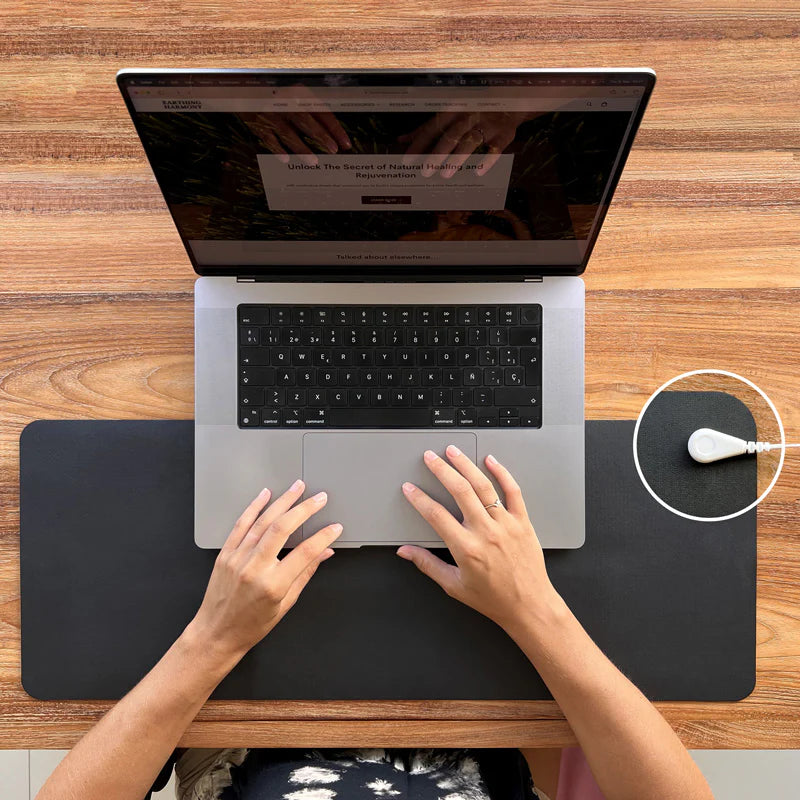 Woman_working_on_macbook_computer_protecting_herself_from_EMF_with_Earthing_mat_3bc93ff3-e7e8-423c-992e-9d7ea0173a89.webp